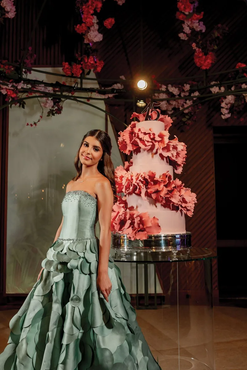 Debutante ao lado de bolo com flores rosa